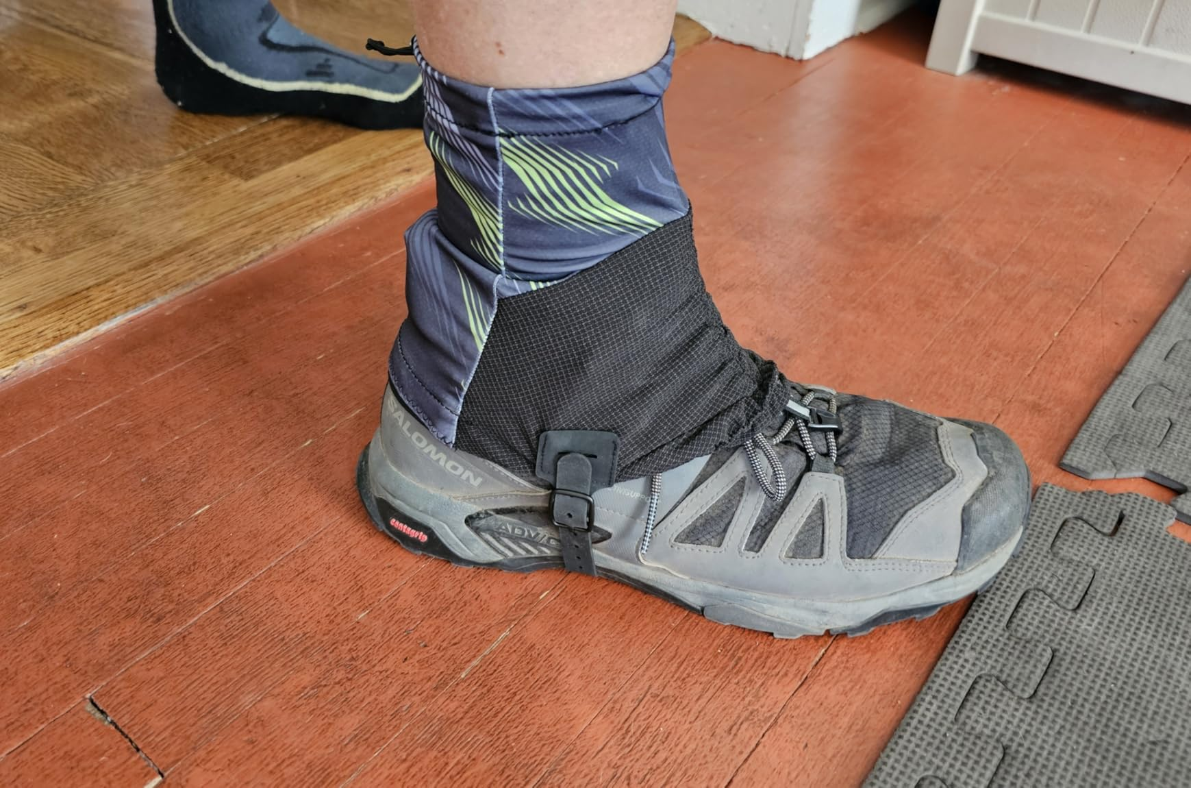 Customer photo of a patterned gaiter fitted over a hiking shoe, showing its side buckle and front lace hook
