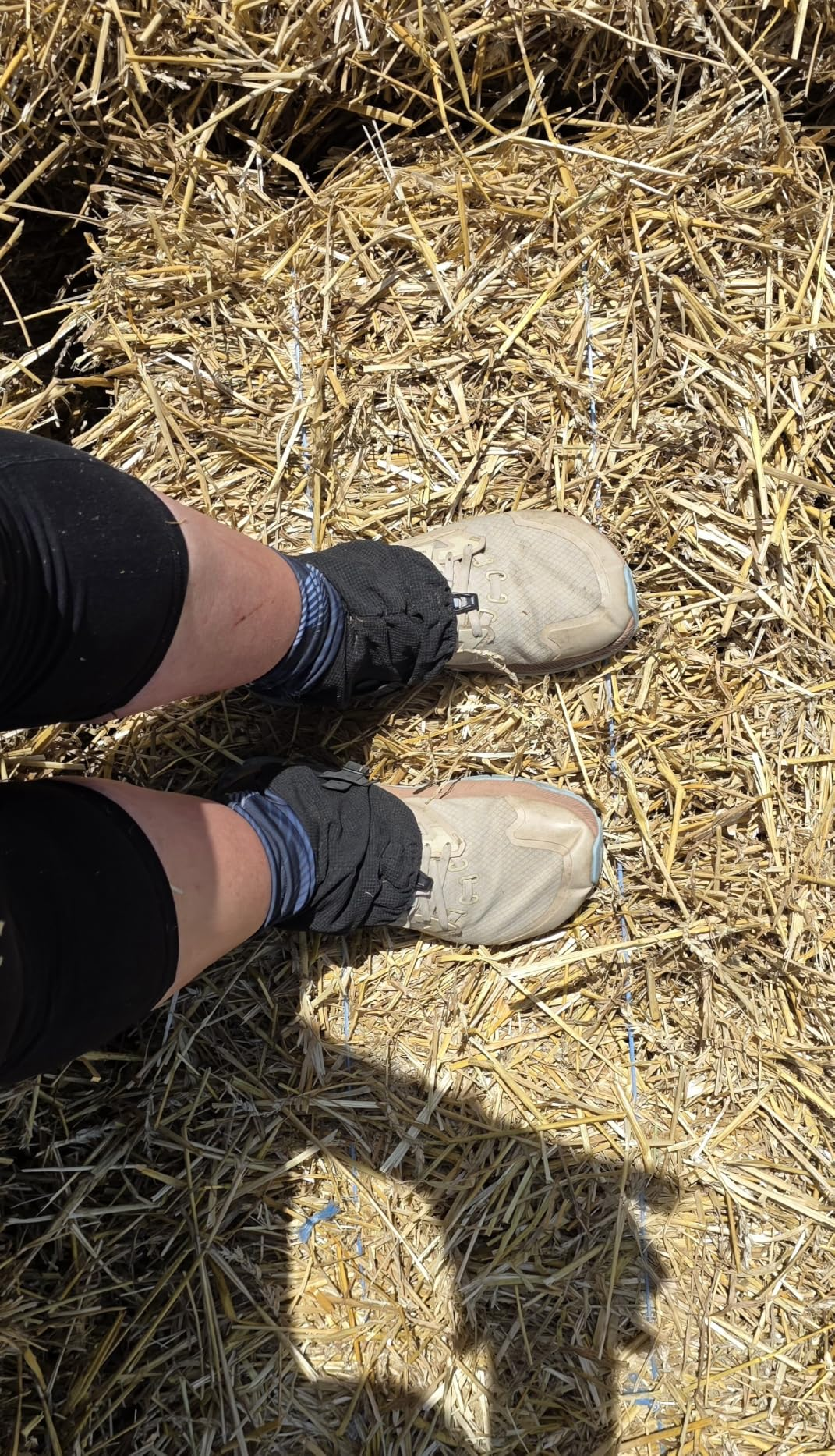 Customer photo of gaiters worn over light-colored shoes while standing on straw
