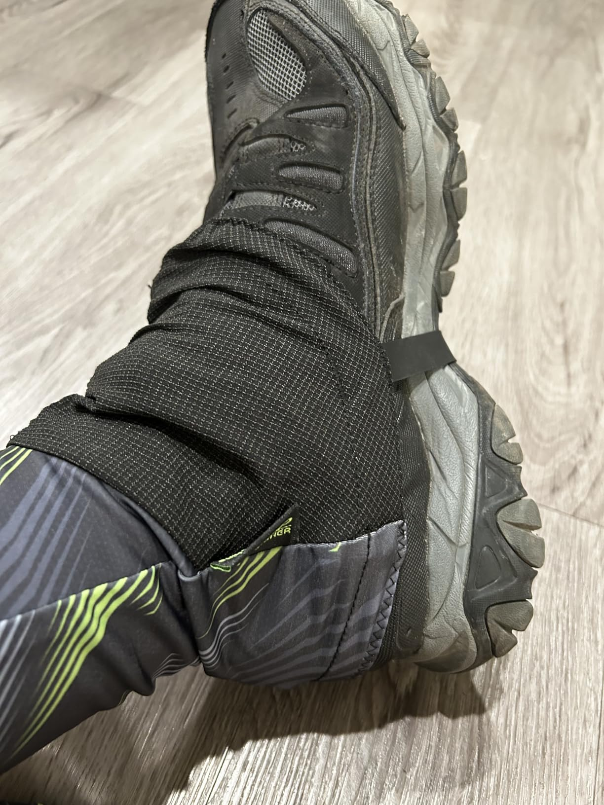 Customer close-up of a patterned gaiter worn over a black hiking shoe, showing the fabric and side strap