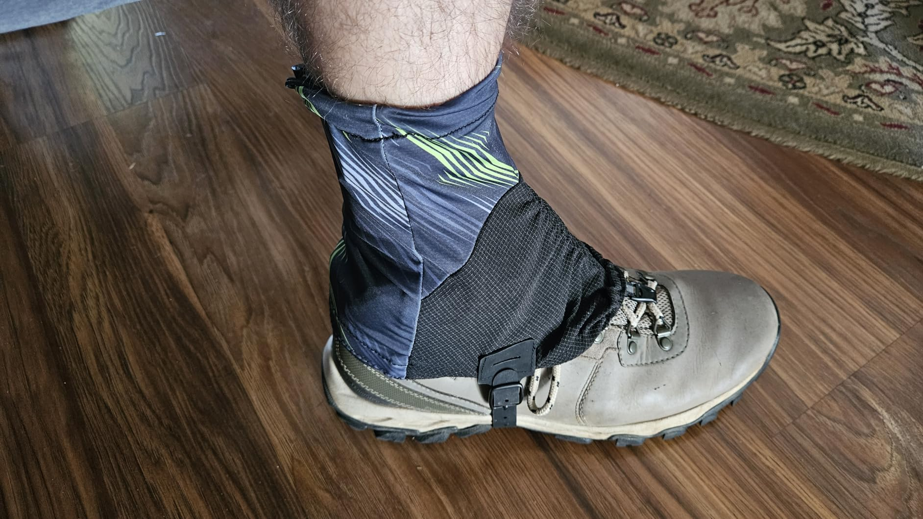 Customer photo of a patterned gaiter fitted over a tan hiking boot, showing the ankle coverage, lace hook and side buckle
